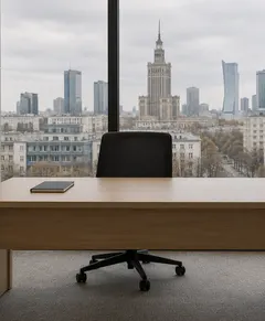 Oak office desk with a black chair by a window